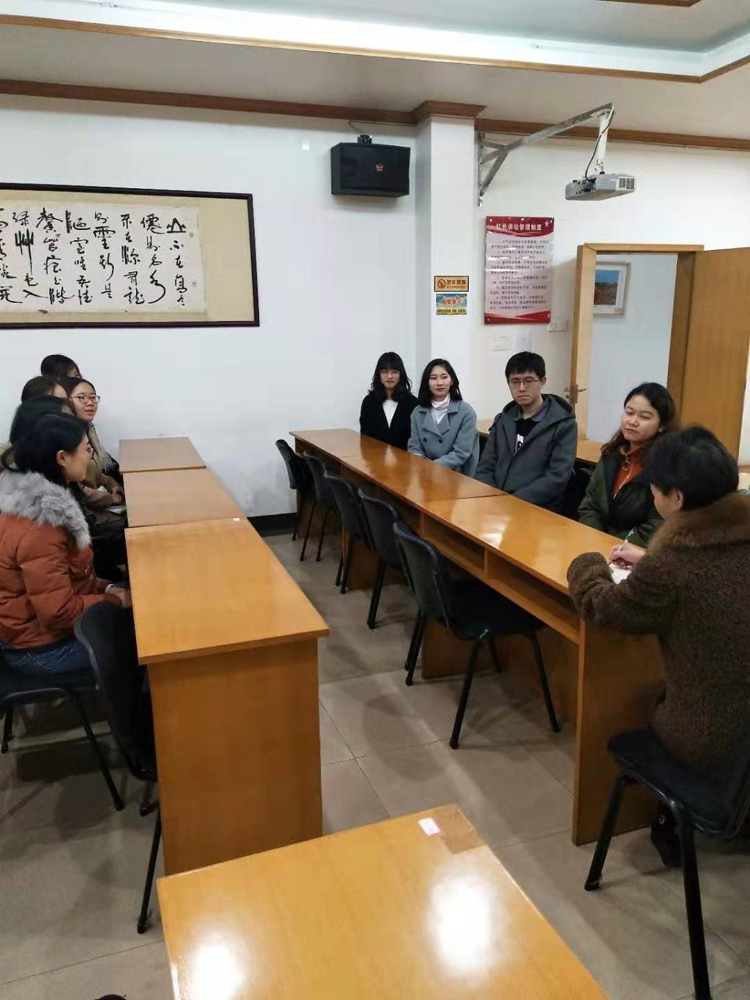 志愿者们认真聆听中心王碧琴主任(右)的讲解